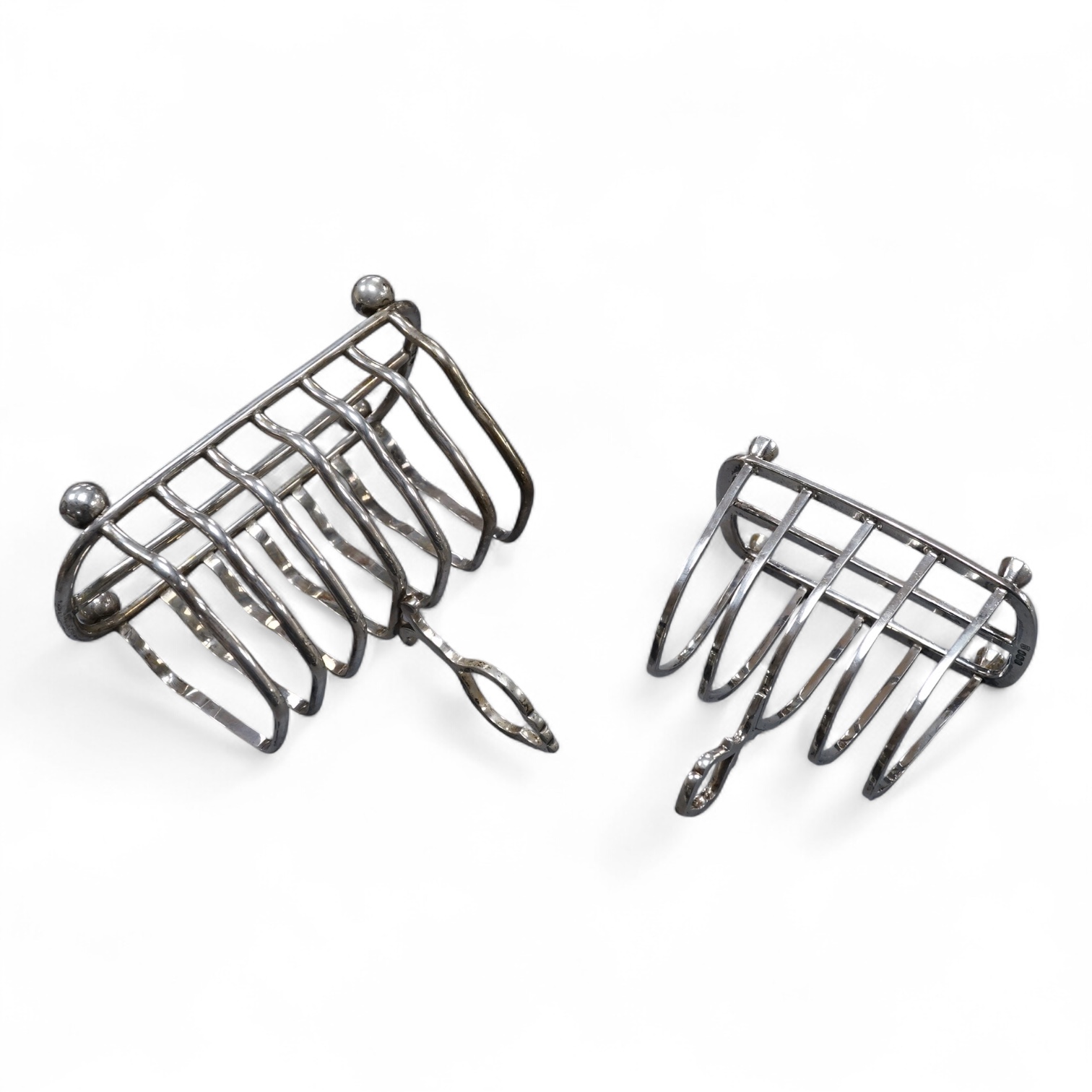 An Edwardian silver seven bar toast rack, by Mappin & Webb, Sheffield, 1902, 15.7cm, together with a George V smaller five bar toast rack, Thomas Bradbury & Sons, Sheffield, 1920, 15.6oz.